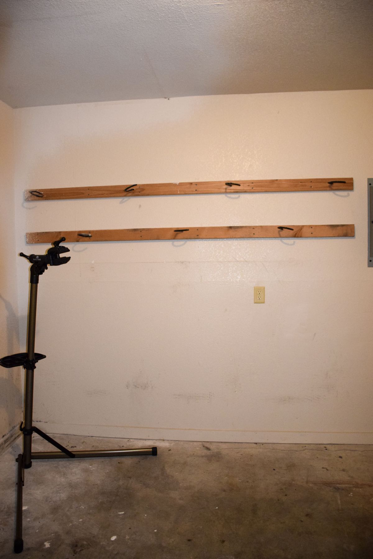 Unit A garage with a bike repair stand and wall hooks
