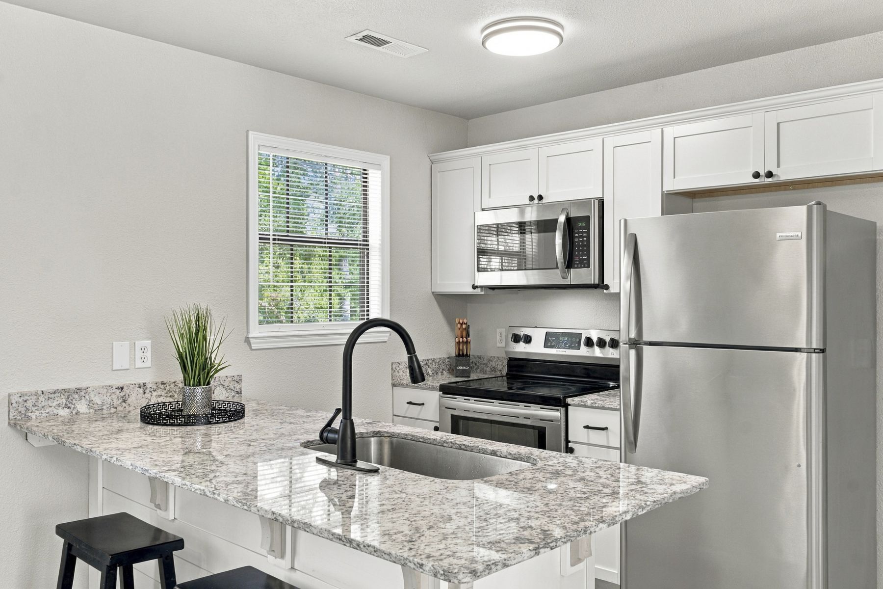 The Trail House kitchen with white shaker cabinets and granite counters