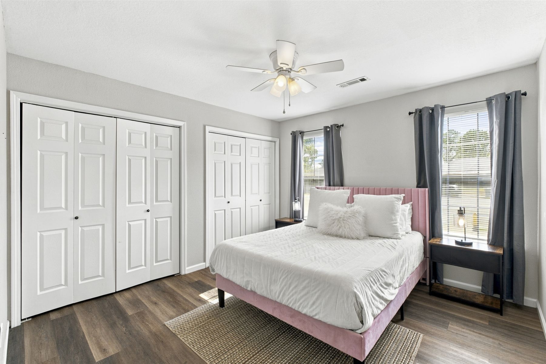 Unit B bedroom with upholstered bed and double closets