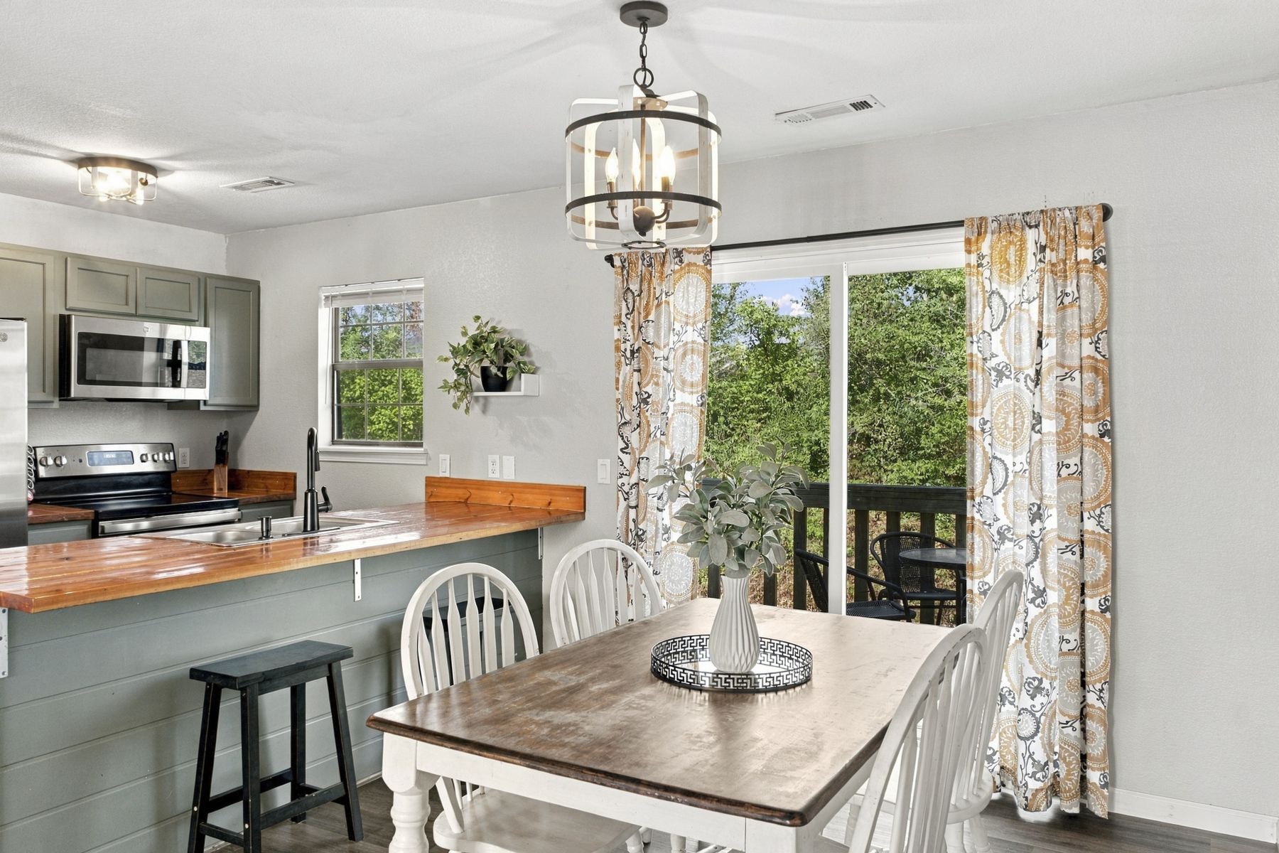 Unit B dining area with farmhouse table and sliding door to the deck
