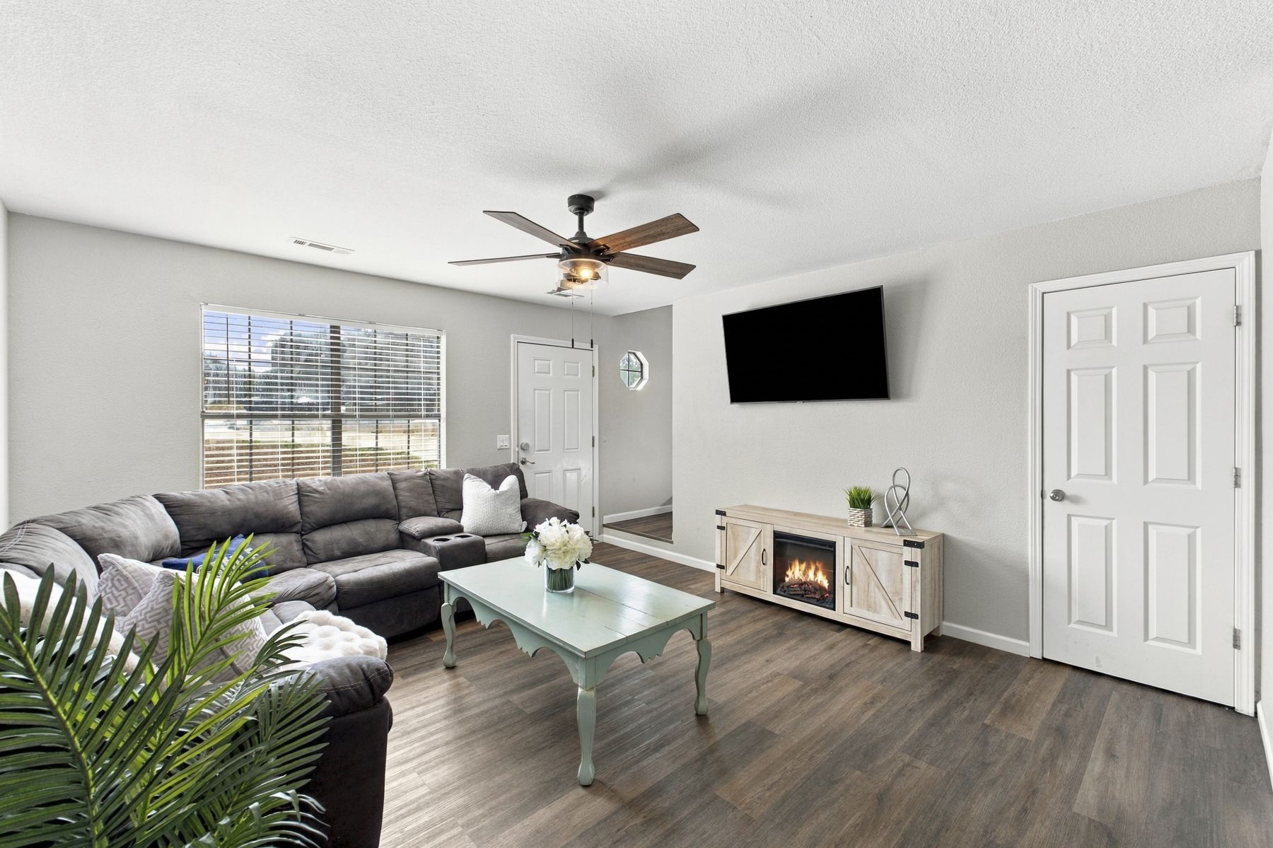 Unit B living room with sectional and electric fireplace