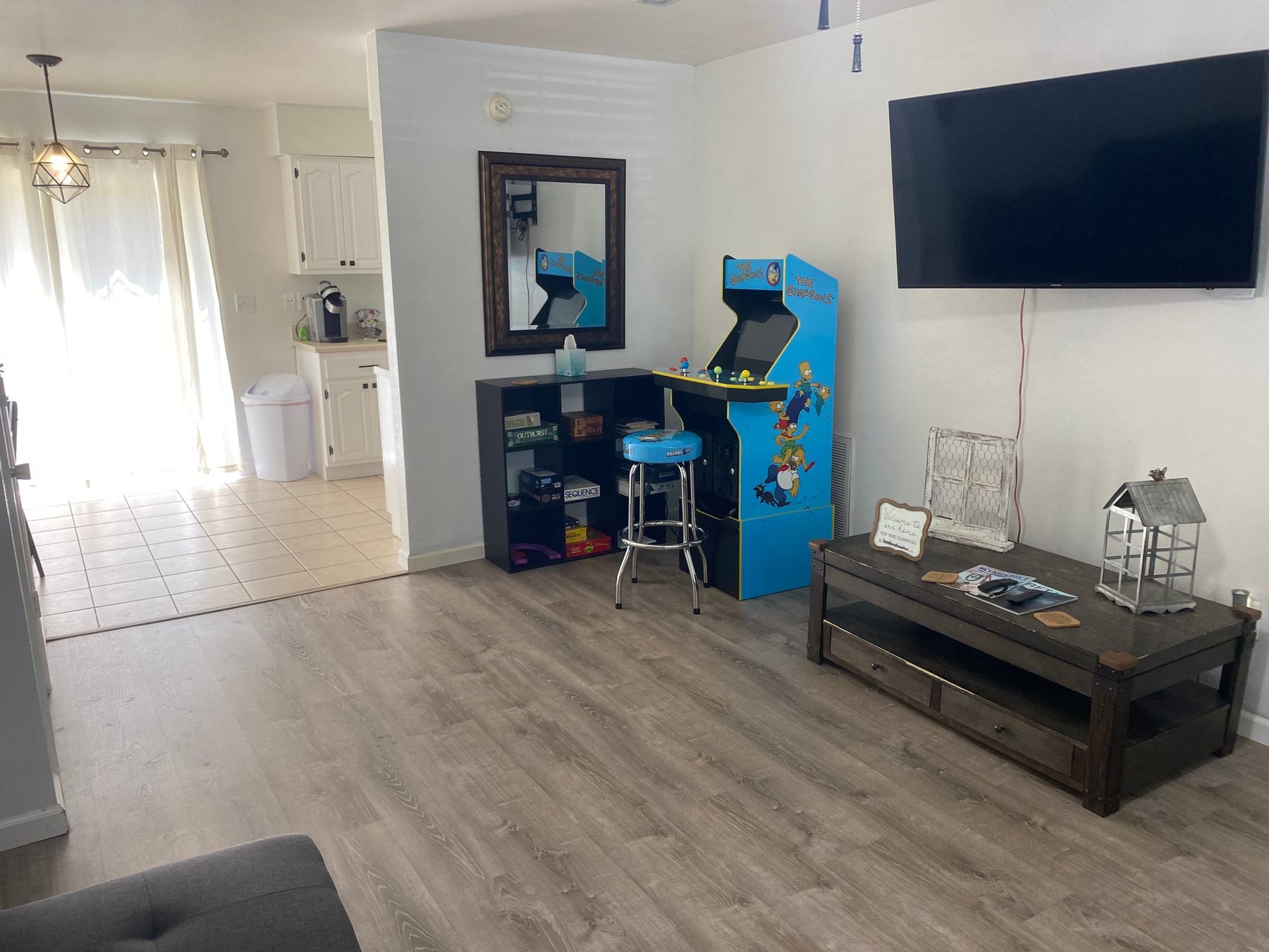 Camellia A living room with the Simpsons arcade cabinet and bikes stored on the wall